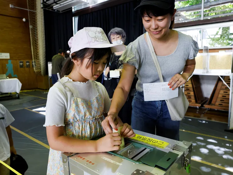日本選民媽媽帶著女兒投票。路透社