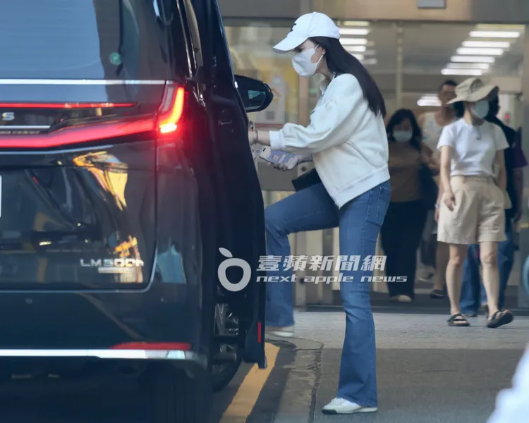 曾馨瑩看似忙碌，一路低頭回訊息離開北醫。特勤中心攝