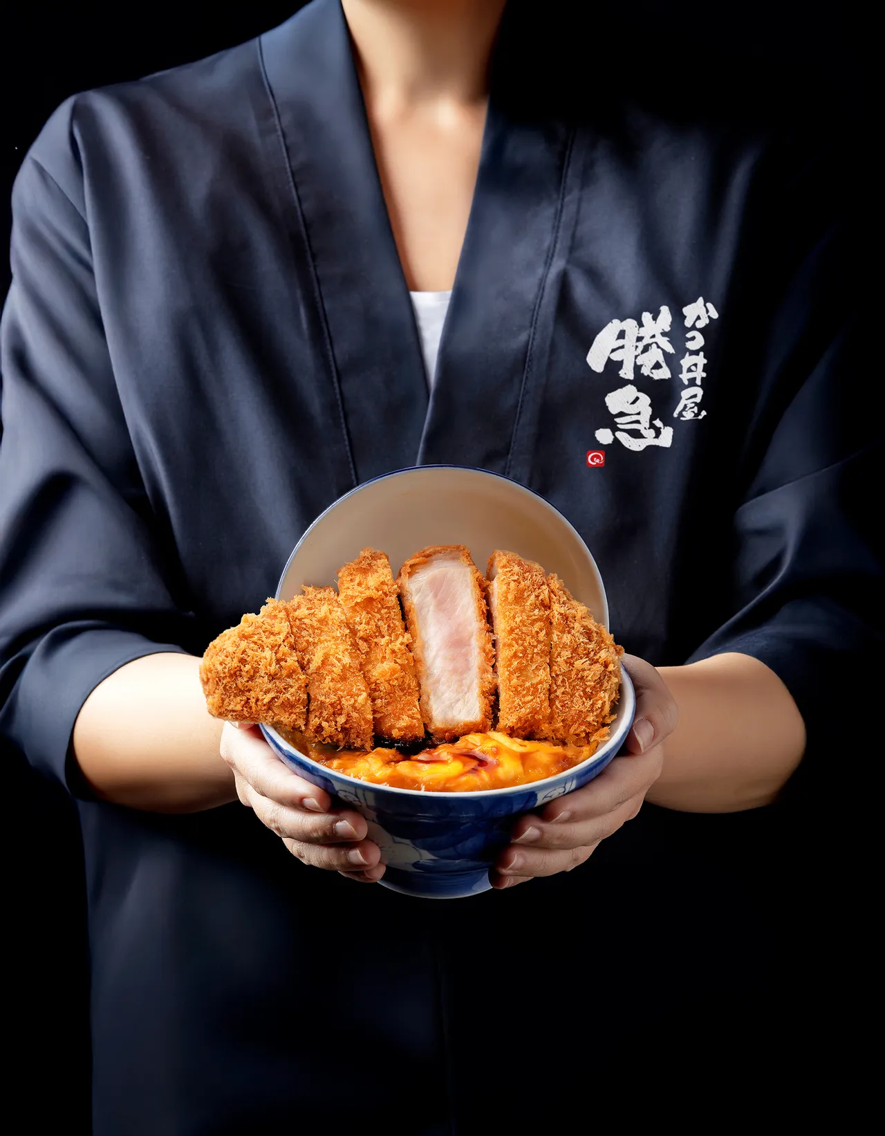 擺盤採用日本精緻彩釉蓋碗,碗蓋立起時呈現如舞台劇般3D空間,超出碗口的厚切豬排,歐姆蛋與豬排分離製作的層層堆疊,帶來視覺與味道撞擊的新食感丼飯體驗。業者提供