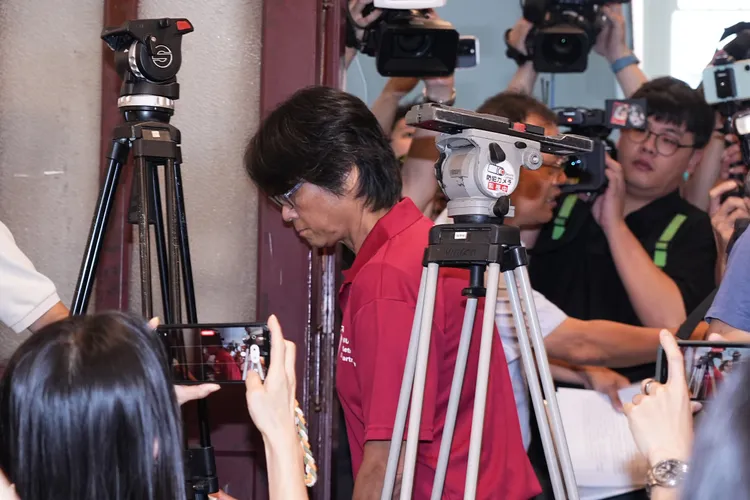 神隱多日的當事教授周台英，今日終於穿紅色上衣現身。彭欣偉攝