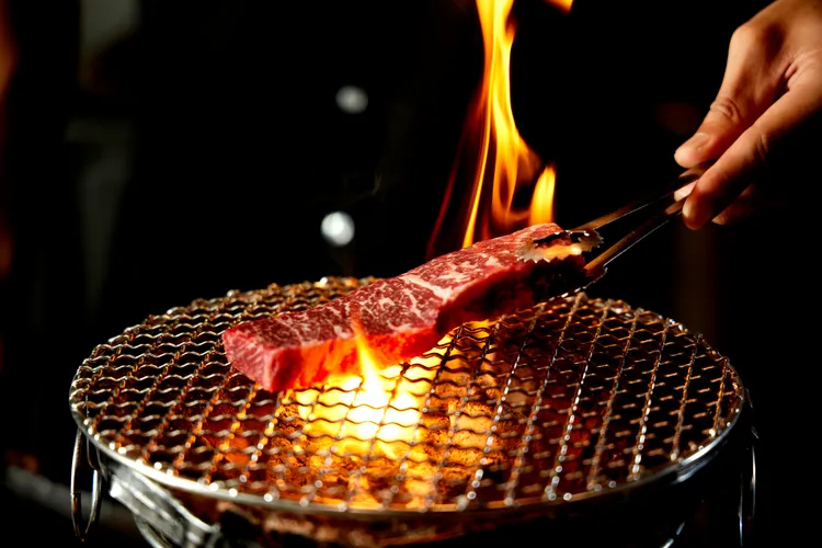 「人情義理牛排」特選炙烤牛排，鐵印「人情義理」四字，上桌時以匾額架承托。業者提供