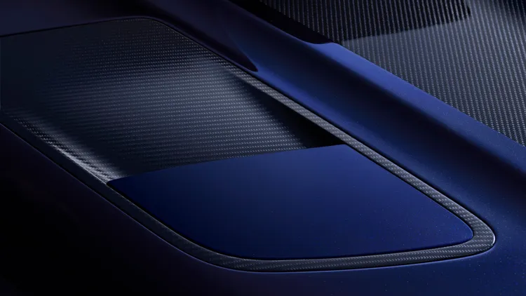 Nocturne 配備外露式碳纖維引擎蓋，搭配緞面斜紋碳纖維套件和黑色鍍鉻金屬文字廠徽，並選用靛藍光澤飾條妝點收尾。原廠照片