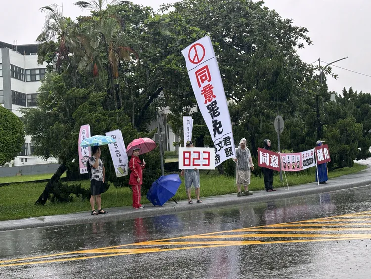 南投罷團志工冒雨在街頭舉牌，呼籲選民投下「同意罷免」。罷團提供
