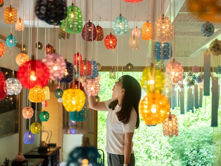 「自遊花人水引博物館」以紅白繩結文化為主題，將200多條水引懸掛裝置在光影中展現出夢幻空間。業者提供