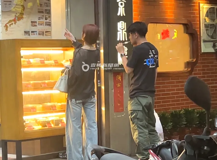 河北彩伽和男伴買完零食戰利品，看到廚窗擺設小籠包模型好奇駐足。特勤中心攝