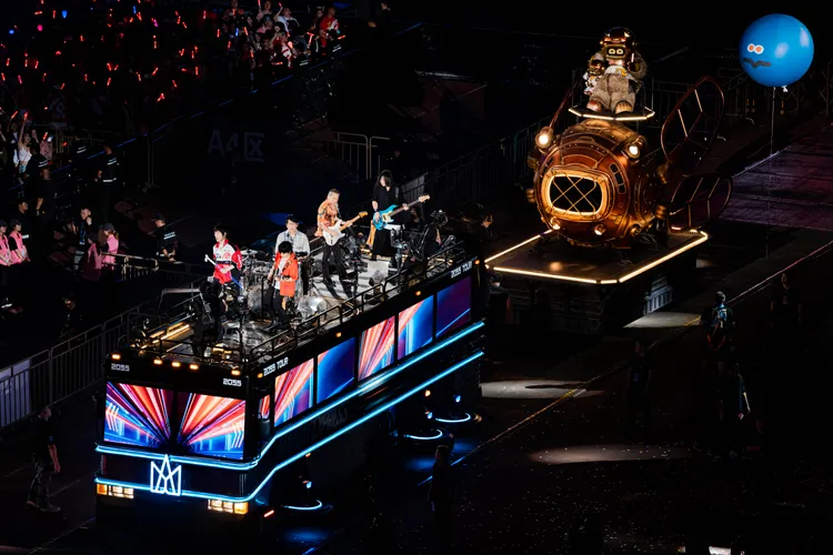 阿信在環場巴士上玩自拍。相信音樂提供