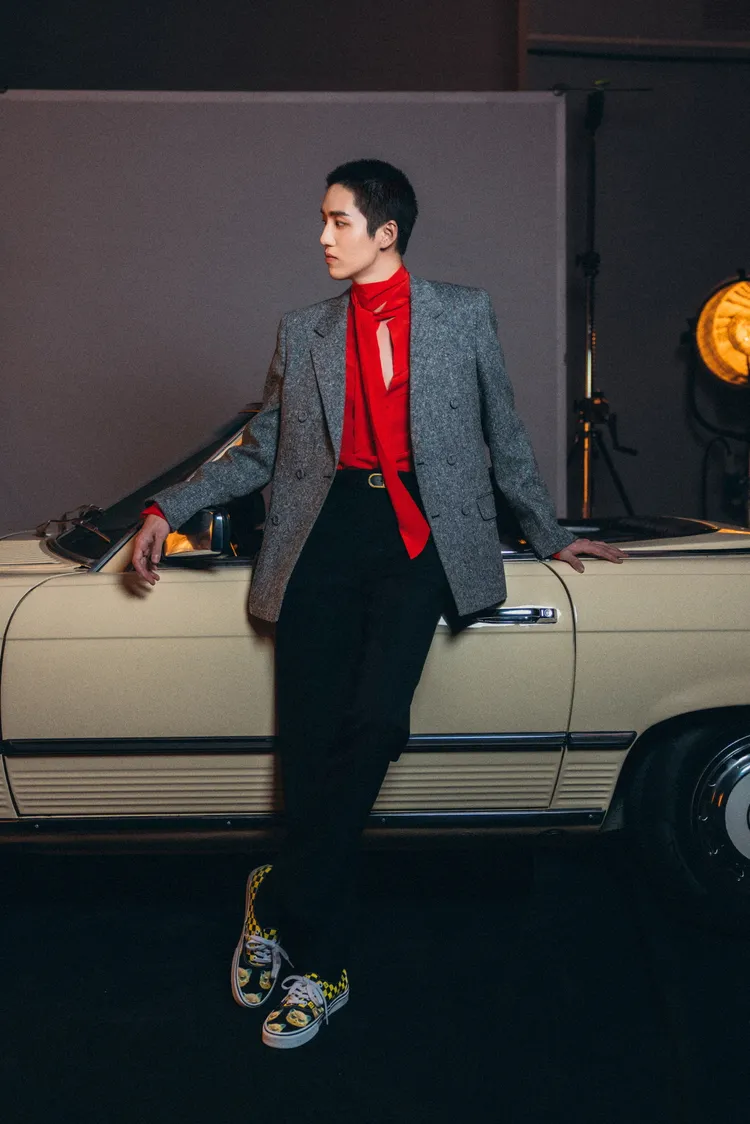 泰國男神塔納波·里拉塔納卡鄒以灰色西裝內搭紅色綁帶襯衫，同樣腳踩貓咪聯名運動鞋。品牌提供