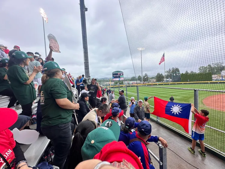 台北市東園國小少棒隊20日在威廉波特世界少棒賽獲勝擊敗委內瑞拉，場邊加油團拿國旗喝采。翻攝東園國小臉書粉專