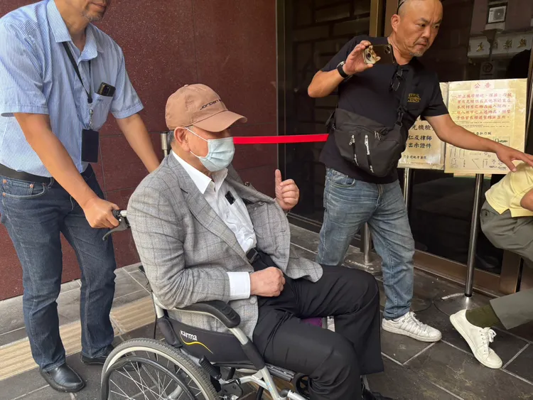 威京集團總裁沈慶京交保後首度出庭，他開庭前坐輪椅進入法院時，左手還伸出大拇指比「讚！」。謝亞庭攝