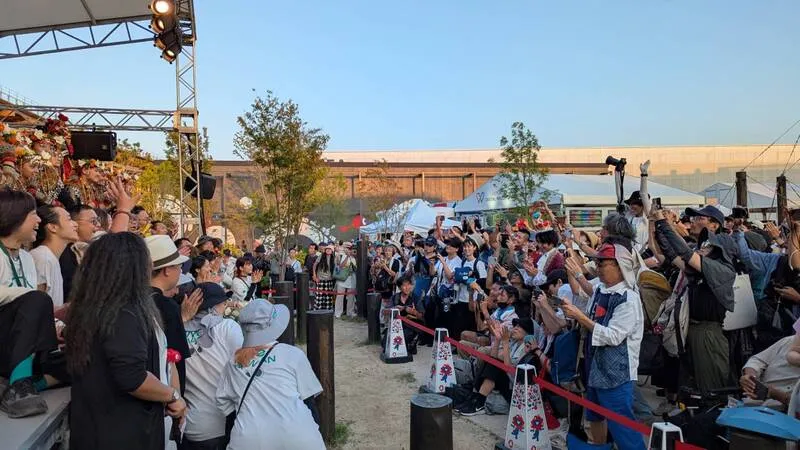 在大阪世博的「岛屿之声:庙埕前的谢神戏」首演结束后,幕前幕后团队26日在舞台前合影,不少本来要离场的日本民众也返回抢拍。 中央社