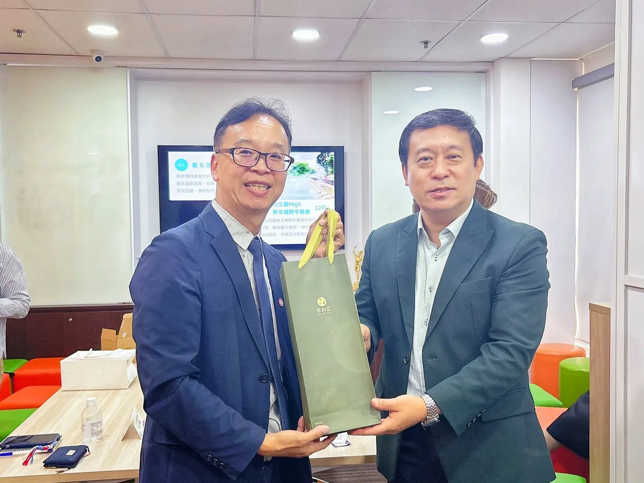 新北观旅局杨宗珉局长(左)在拜会大通旅行社时致赠坪林茶点。观光局提供