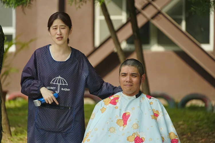 黃恩賜（右）被百白剃完頭髮，有點笑不出來。台視提供