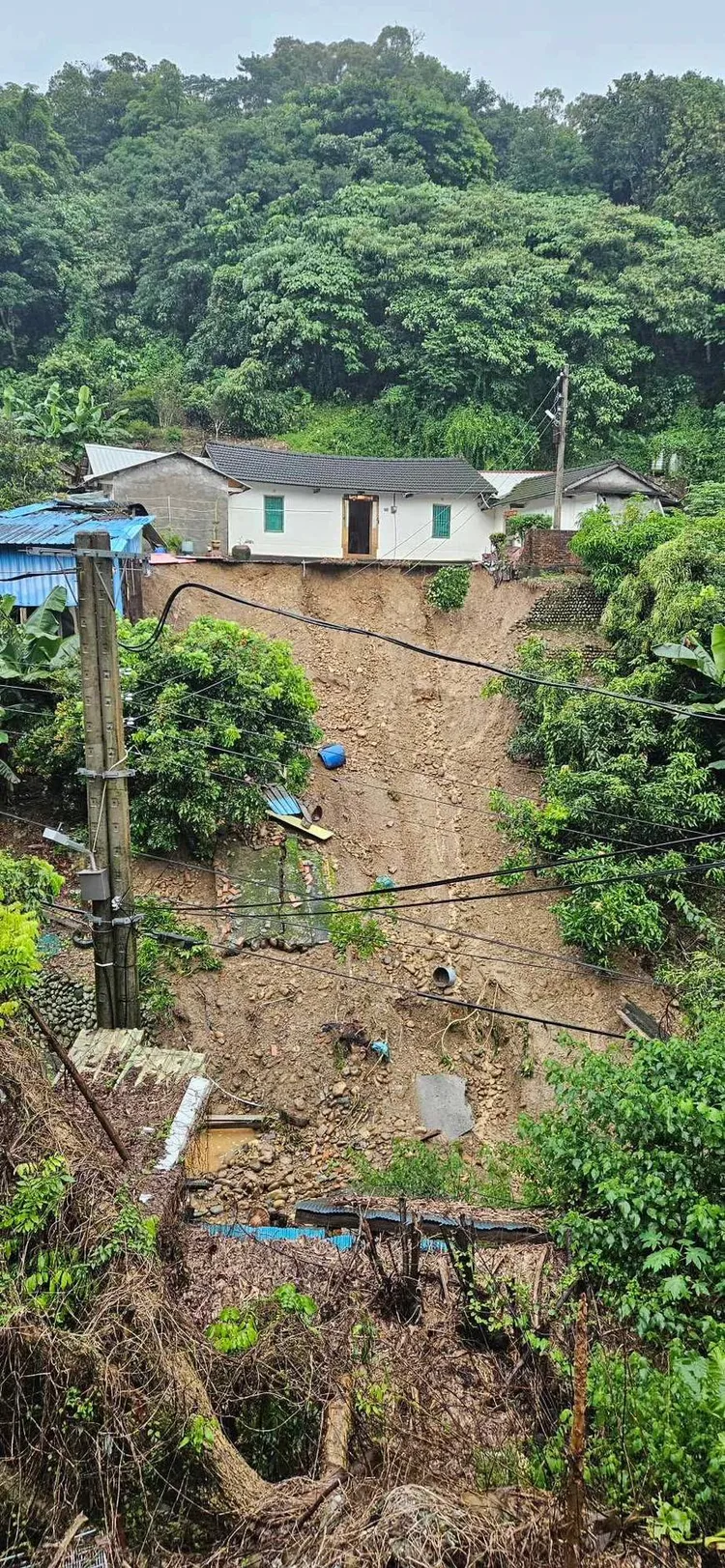 三合院主建物懸在邊坡上，搖搖欲墜，看起來相當危險。民眾提供