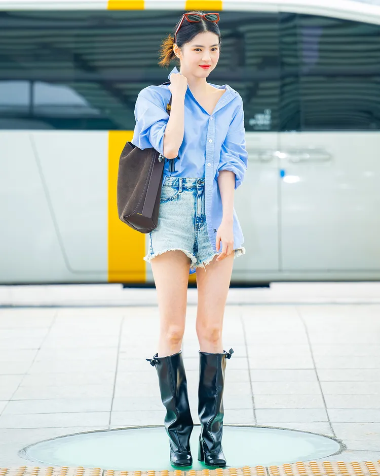 韓素希機場造型以藍色襯衫搭配不修邊牛仔短褲，俐落又休閒。品牌提供
