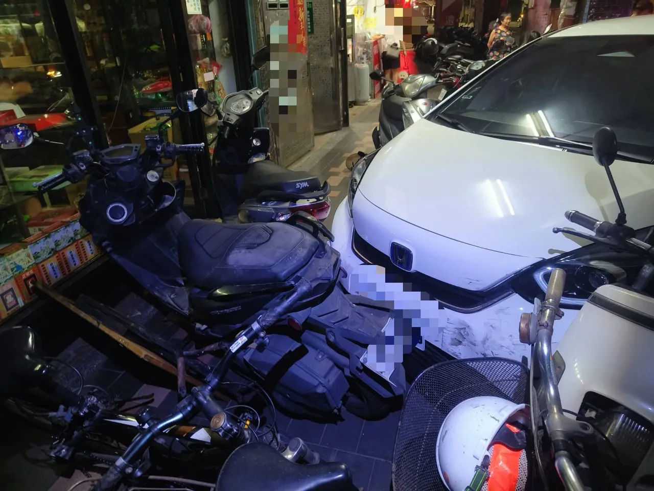 现场被撞机车、自行车喷飞,东倒西歪,租赁车头也受损。翻摄画面