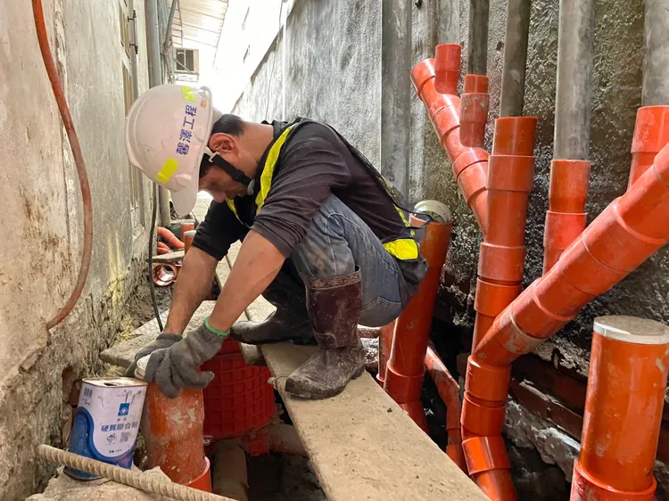施工人員在後巷中進行污水接管。水利局提供