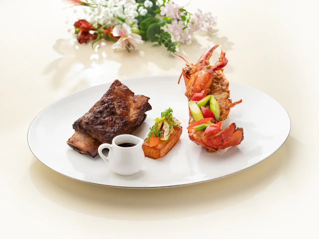 文華Café「平日午間饗.吃.吧」推出全新季節主餐,「爐烤美國Prime帶骨牛小排及X.O.醬波士頓龍蝦」以奢華雙饗帶來夏日午間的極致盛宴。圖北文華東方酒店提供