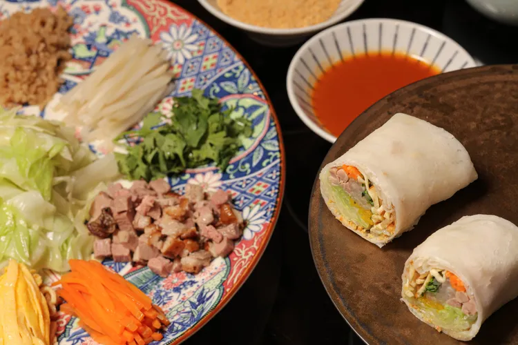 充滿台式傳統滋味的「古早味鴨鬆潤餅」由賓客自由組合高麗菜、豆乾絲、蛋絲等豐富配料，搭配鹹香柔嫩的鴨肉丁，每一口都能嘗到餡料與Q彈餅皮交織的美好滋味。台北晶華提供