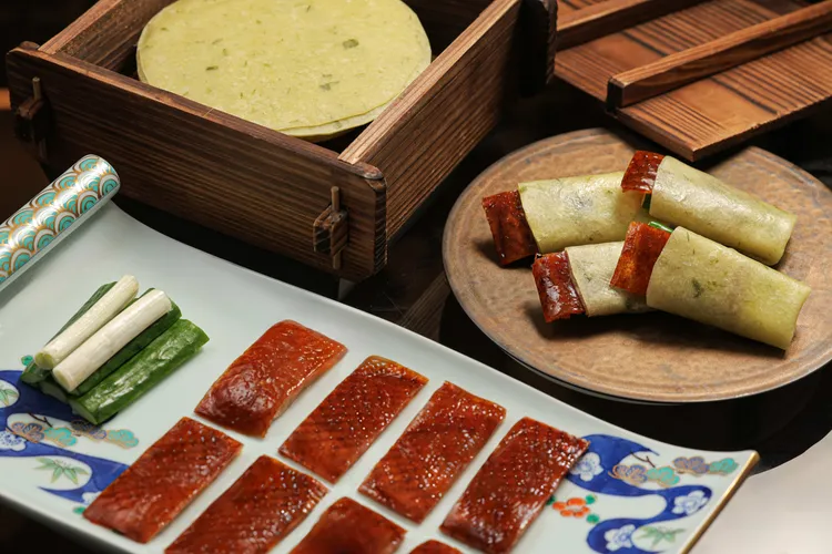 招牌「三星蔥片皮鴨捲」則展現片鴨料理的經典魅力，主廚以手工桿製的三星蔥餅皮包裹鮮嫩鴨肉與酥脆鴨皮，搭配特製甜麵醬、蔥段與黃瓜，層次分明、口感豐富。台北晶華提供