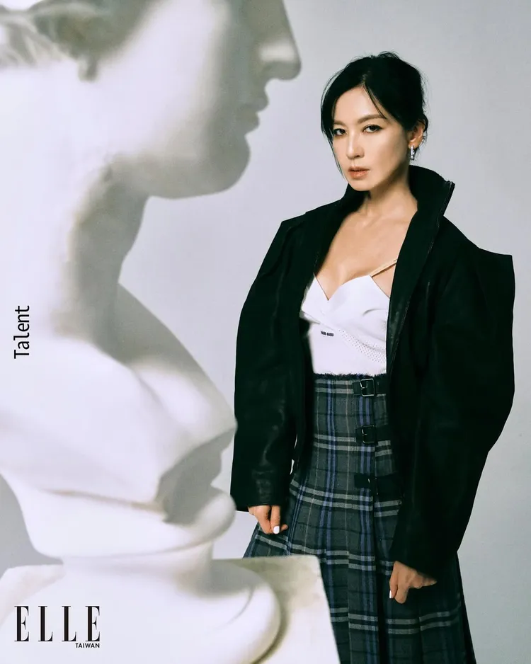 林熙蕾另以白色低胸細肩帶背心配上格紋裙、皮革立領外套。翻攝elletaiwan IG