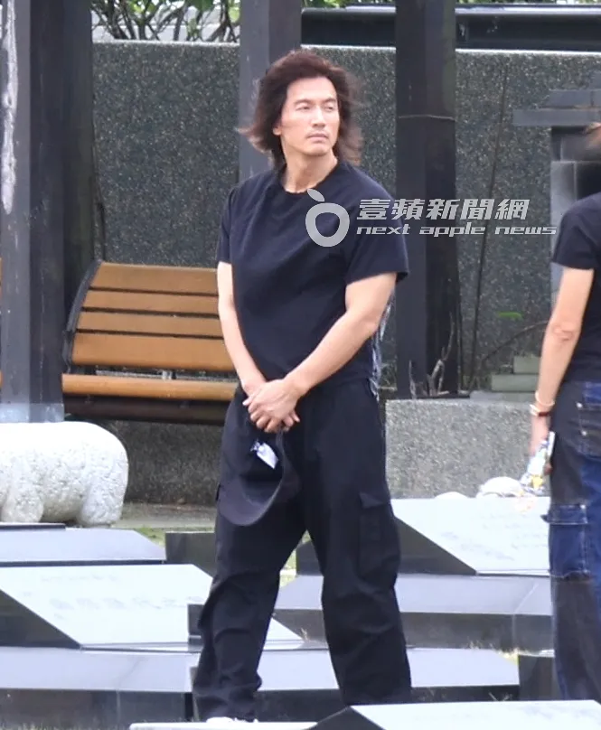 言承旭將帽子拿在手上，看看大S墓園四周環境。特勤中心攝