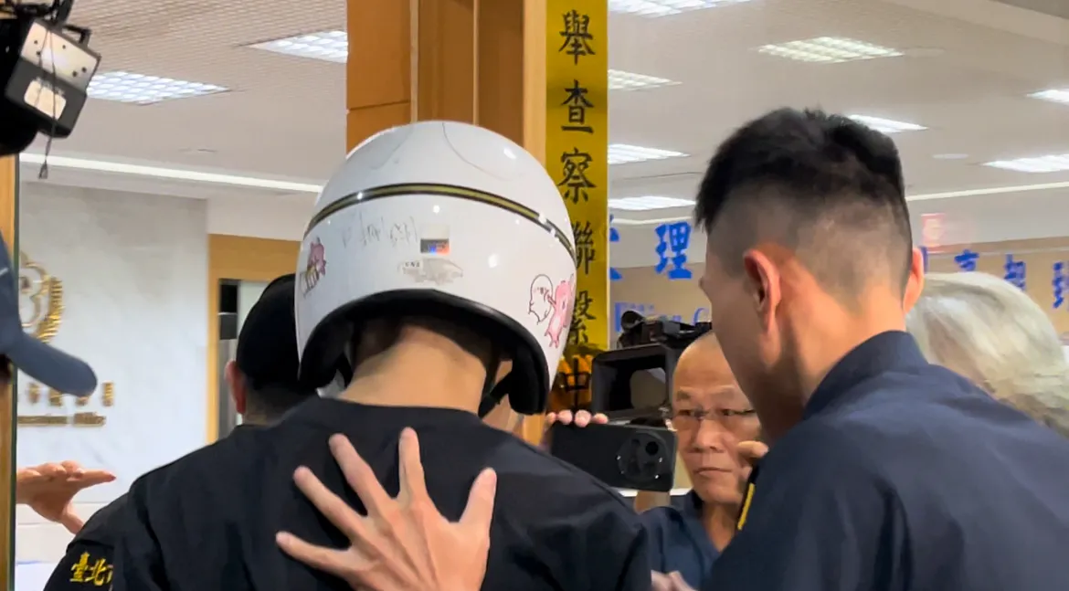 刘男头戴有「卡娜赫拉」图样的安全帽抵达北检。谢亚庭摄