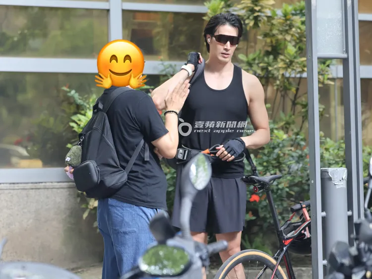 錦榮（右）聽著經紀人滔滔不絕，準備騎腳踏車。特勤中心攝