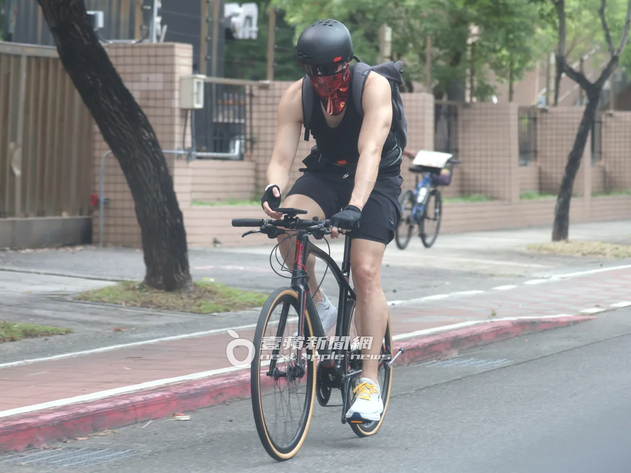 锦荣化身Taipei Biker,边骑乘脚踏车边使用手机。特勤中心摄