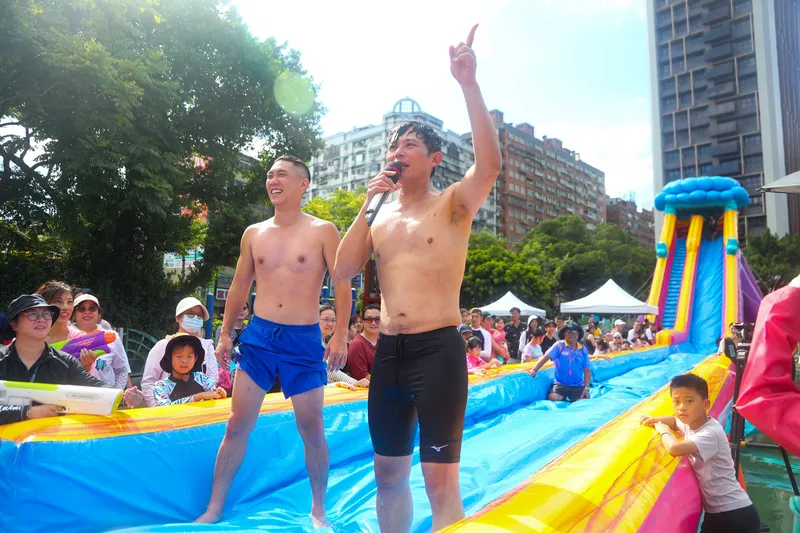 民众党新北市议员陈世轩(左)17日主办「JIMMY摇滚水乐园」活动,党主席黄国昌(右)打赤膊体验滑水道,进行趣味竞赛。中央社