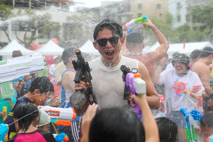 民眾黨新北市議員陳世軒17日主辦「JIMMY搖滾水樂園」活動，黨主席黃國昌（中）帶水槍與小朋友同樂。中央社