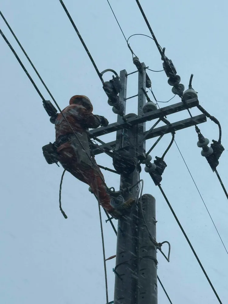 台電人員冒雨搶修電力。台電公司提供