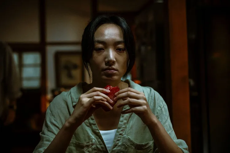 蔡思韵撕咬生肉展現遭邪靈附身的詭譎狀態。天予電影提供