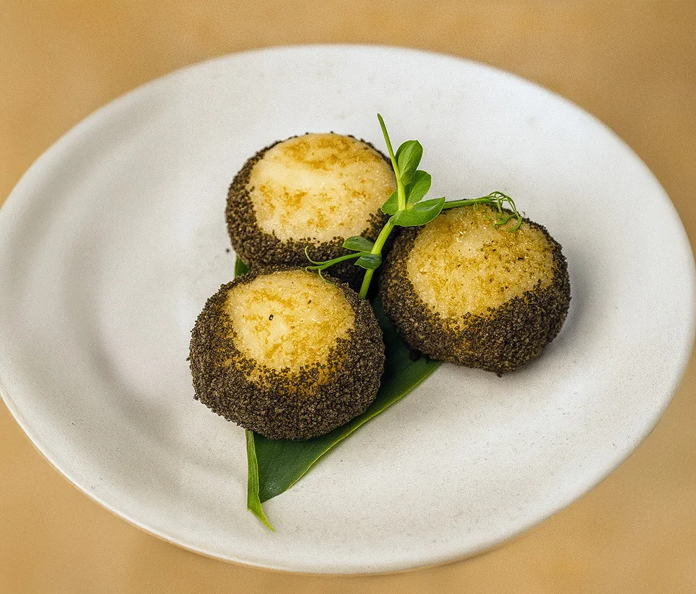 創新港式甜點「金沙薯糍」,金沙內餡搭配椰奶與鮮奶油,口感滑順又甜中帶鹹,入口後芝麻香氣濃郁。業者提供