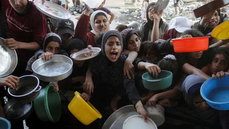 巴勒斯坦難民爭相搶著拿慈善機構的糧食。路透社資料照片