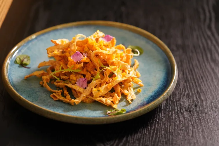 鹹香酥脆的金沙鱈魚香絲是弈夢紅樓招牌開胃菜，讓人一口接一口吃。瀚寓酒店提供