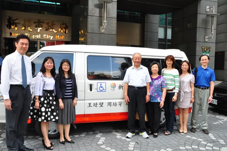 王覺生帶著家人捐贈復康巴士。家屬提供