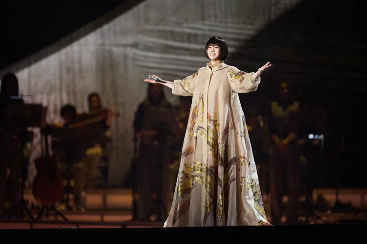 江蕙穿上夏姿專屬訂製舞台服，粉膚水墨烏干紗袍和金蔥透膚刺繡禮服。寬宏藝術提供