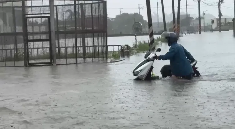 積淹水嚴重，民眾只能牽著機車涉水而過。民眾提供