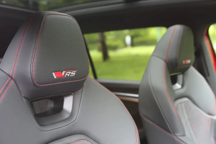 紅色縫線沿著椅面勾勒出鮮明線條，頭枕上的RS字樣像是一枚性能印章。林浩昇攝