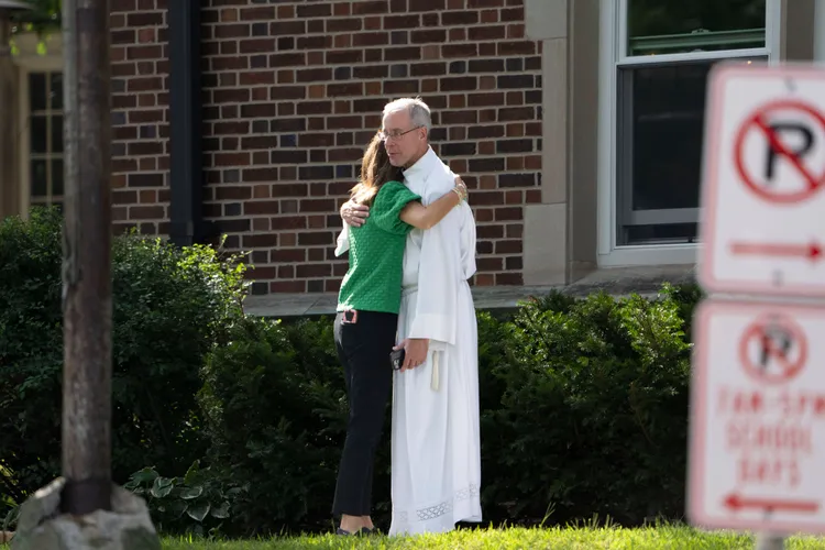 學校的天主教神職人員安撫劫後餘生的工作人員。美聯社