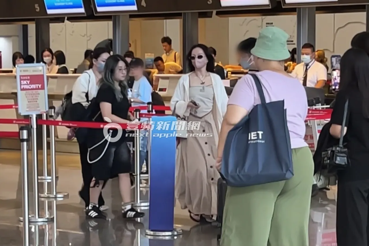 张韶涵在航空公司柜台办理登机手续挂行李。特勤中心摄