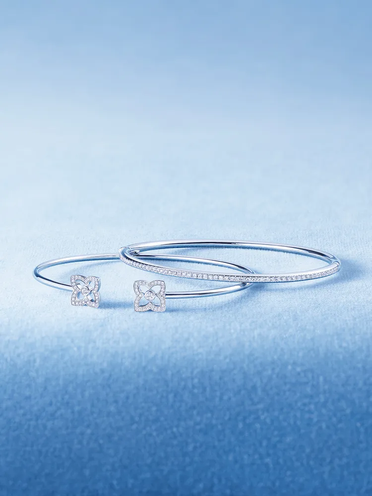 De Beers全新Enchanted Lotus Bloom 18K白金鑽石開放式手鐲（左）14萬6000元。品牌提供