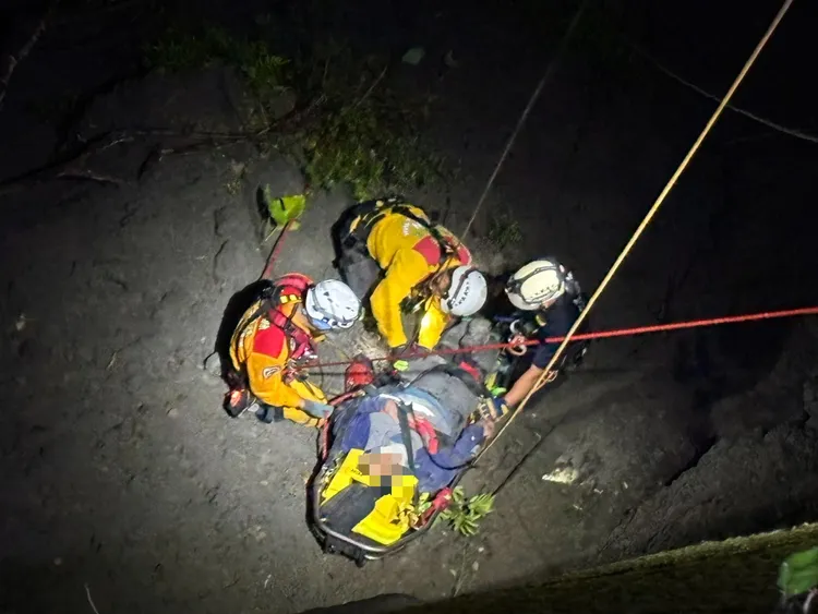 機車摔落50公尺深山谷，消防人員協助脫困送醫。翻攝畫面