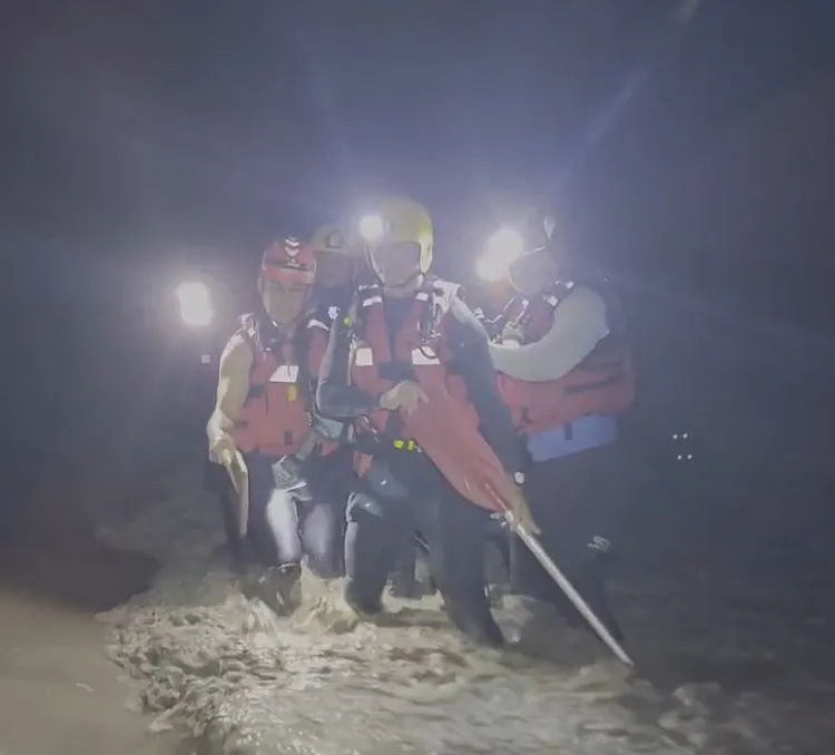 6名大橋特搜人員渡河接觸方婦，把她圍在中間，小心翼翼救人。民眾提供