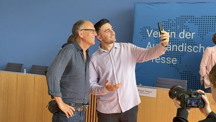 2015年因與梅克爾自拍爆紅的敘利亞難民莫達馬尼（右），26日在柏林舉行的難民危機十週年座談會上，與當年拍下這張照片的攝影記者蓋洛普（左）重逢，兩人自拍溫馨合影。 中央社