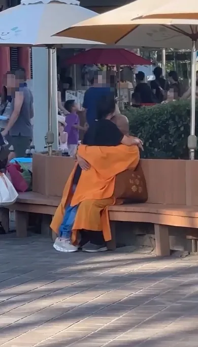 和尚裝扮的男子與女子在兒童樂園內擁抱。翻攝畫面