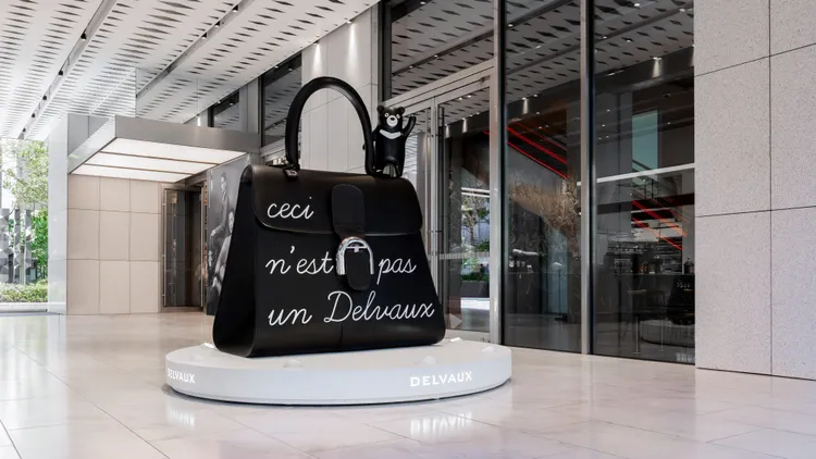 包身上的文字「Ceci n’est pas un Delvaux」，忠實還原馬格利特經典畫作的俏皮感。品牌提供