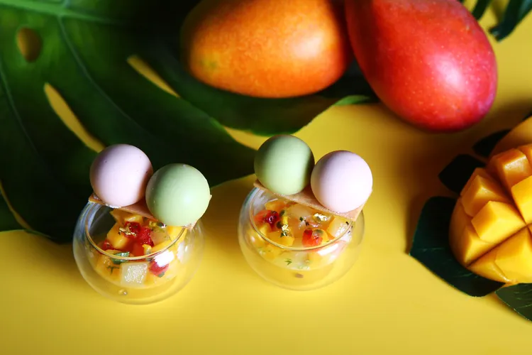 台北萬豪Lobby Lounge「芒芒仲夏」下午茶，「四季春多多白桃芒果冰球」小巧杯子放上四季青多多冰球和白桃芒果冰球，杯子內則是多款新鮮水果搭配百香果醬。業者提供