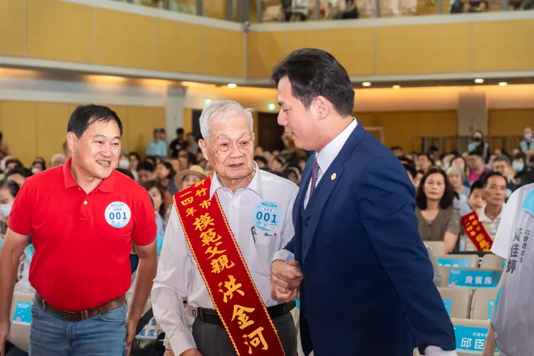 臣遠陪伴今日最年長模範父親洪金河爺爺上台接受表揚。新竹市府提供