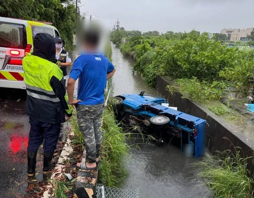 颱風過境天雨路滑 小貨車閃前車翻落排水溝 駕駛脫困幸無恙